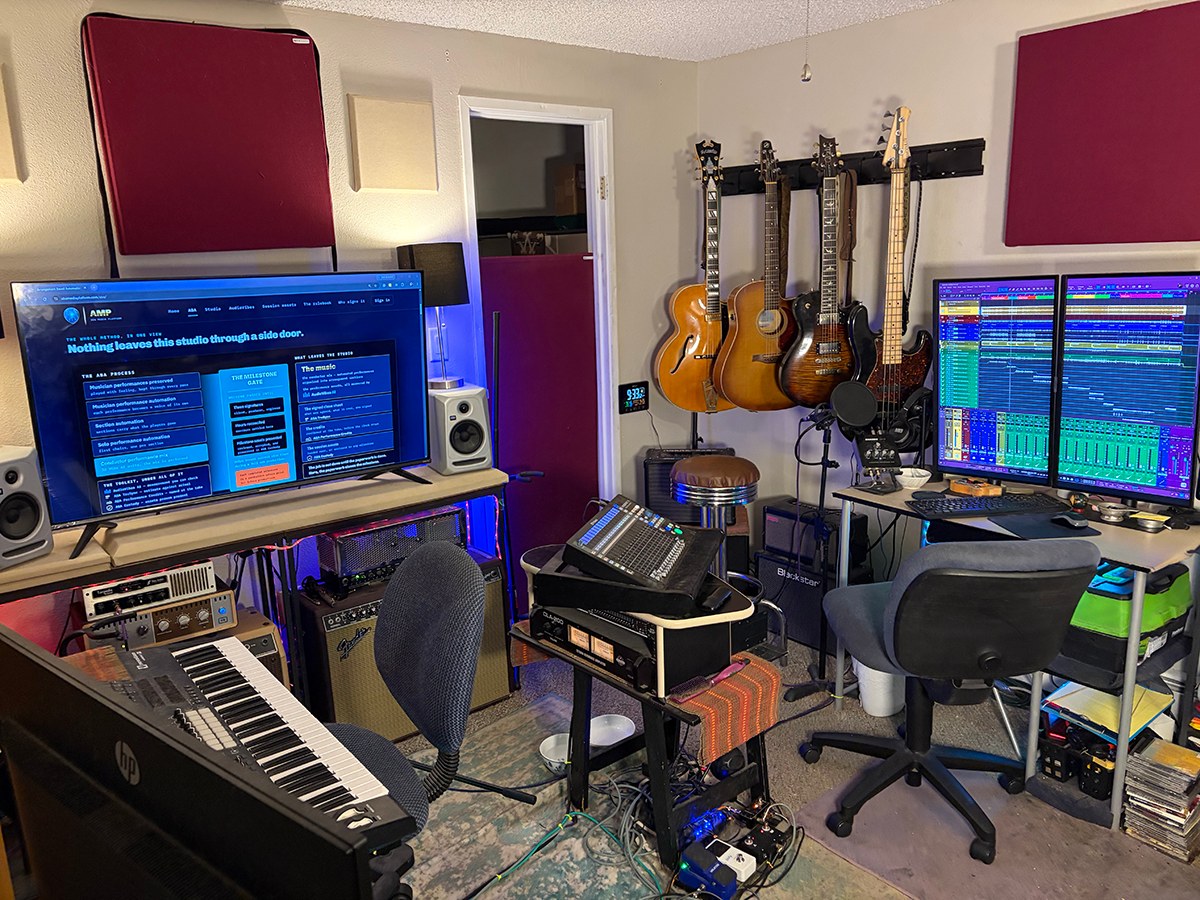 The ABA studio room in Greeley, Colorado: the keyboard, guitars on
                  the wall, the amps, the desk, and the ABA site on the main screen